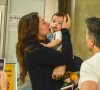 Claudia Raia é recepcionada pelo marido e filho caçula em aeroporto