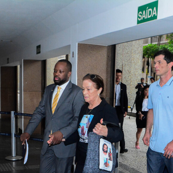 Mãe de Jeff Machado foi em audiência com camisa e bolsa com fotos do ator