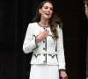 Kate Middleton combinou agasalho de frio e saia midi plissada nesse look branco com detalhes pretos