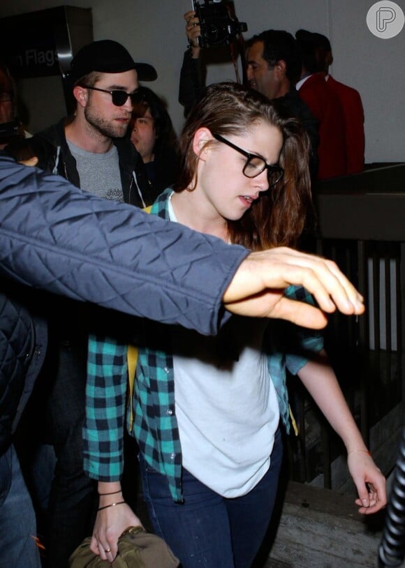 Kristen Stewart e Robert Pattinson são ajudados por seguranças