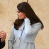 Kate Middleton conversa durante o evento e segura a barriguinha