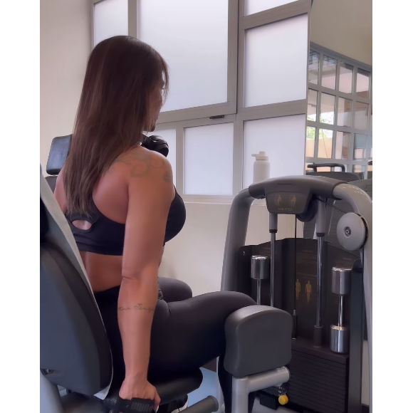 Em seguida, Kelly Key faz a cadeira abdutora m sua rotina de treinos