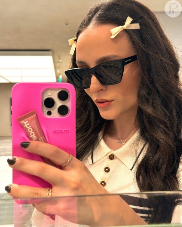 Larissa Manoela é considerada it girl fashionista e não dispensa bons acessórios, como óculos, presilhas de cabelo, além da sua capinha de celular tendência do momento.