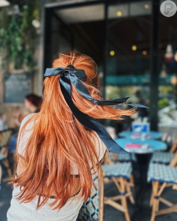 O maxi laço preto escolhido por Giovanna Lancellotti deu destaque ao seu visual de cabelos ruivos.