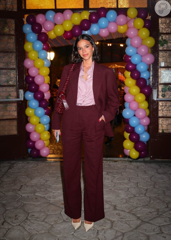 Bruna Marquezine elegeu um blazer oversized na cor marsala com uma bolsa no mesmo tom para curtir sua festa de aniversário