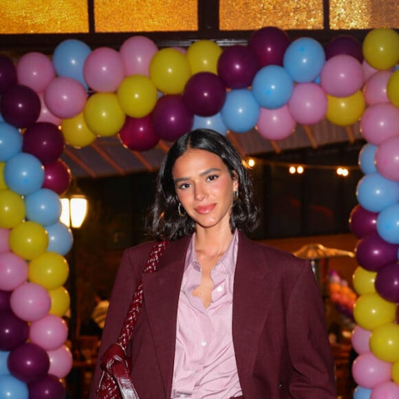 Bruna Marquezine elegeu um blazer oversized na cor marsala com uma bolsa no mesmo tom para curtir sua festa de aniversário