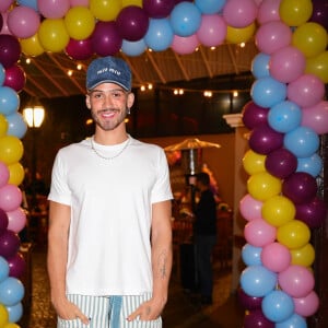 Já João Guilherme escolheu uma combinação de calça oversized listrada e camiseta branca, com boné jeans