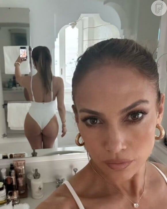 Em uma das fotos, Jennifer Lopez provocou ao mostrar seu bumbum turbinado em um maiô branco colado