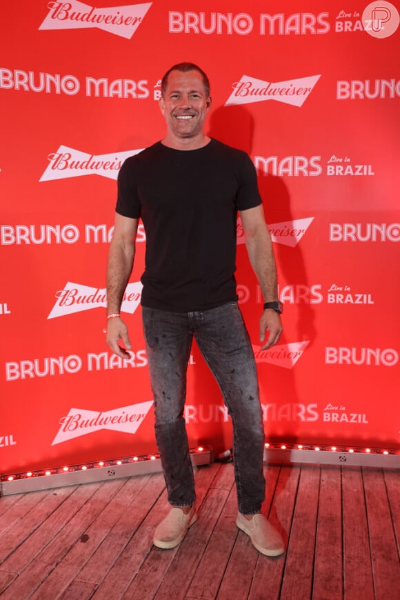 Malvino Salvador escolheu calça jeans cinza e camisa preta para o show de Bruno Mars