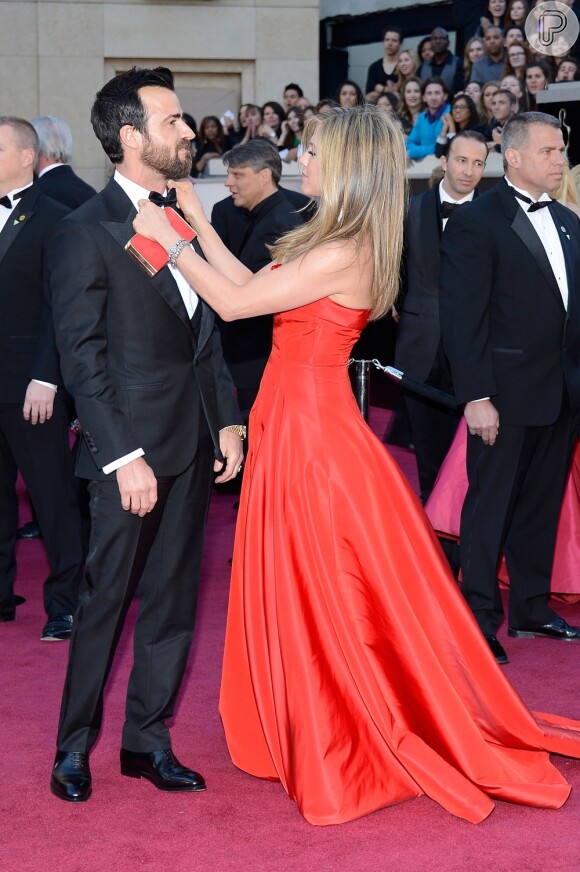 Jennifer Aniston ajeita a gravata do noivo, Justin Theroux, no tapete vermelho do Oscar 2013