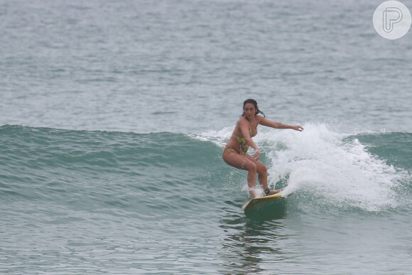 Daniele Suzuki não se importou com a terça-feira nublada e foi pegar onda na praia da Macumba, na Zona Oeste do Rio. Usando um maiô 'engana-mamãe', a atriz, que está no ar em 'Malhação', chamou a atenção para sua boa forma