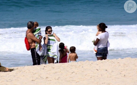 Cláudia Abreu costuma ser bem discreta e evita se expor. Antes de deixar a praia, ela se enrola na toalha