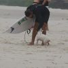 Cauã Reymond brinca com um cachorro na praia de Joatinga, na Zona Oeste do Rio de Janeiro, nesta segunda-feira, 16 de março de 2015