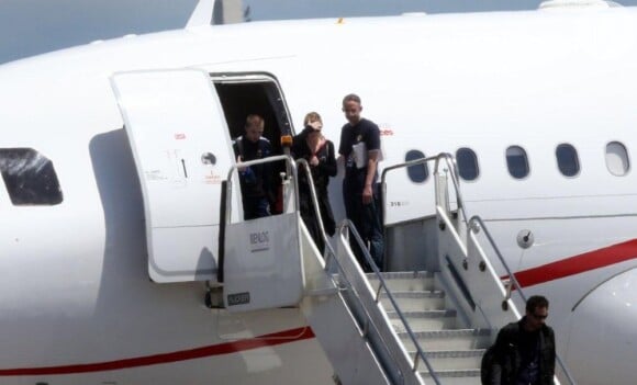 Madonna desce as escadas do avião que a trouxe da Colômbia