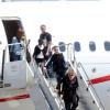 Madonna desce as escadas do avião acompanhada por seus filhos