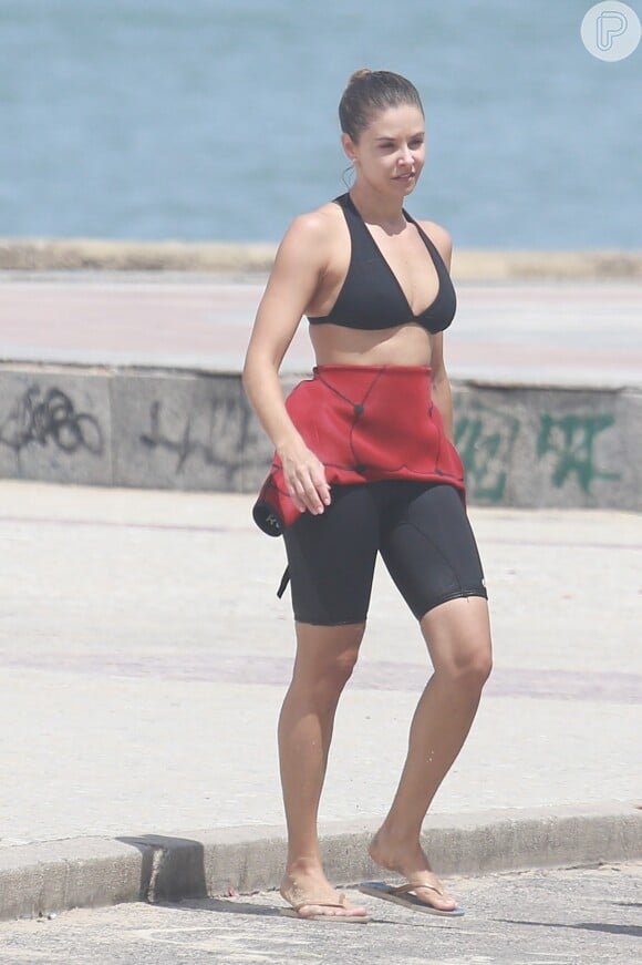 Ao sair da praia, Bianca Rinaldi mostrou sua boa forma, ainda com a roupa especial de surfe
