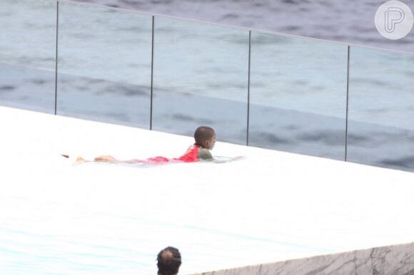 David Banda, filho de Madonna, curte a piscina de roupa
