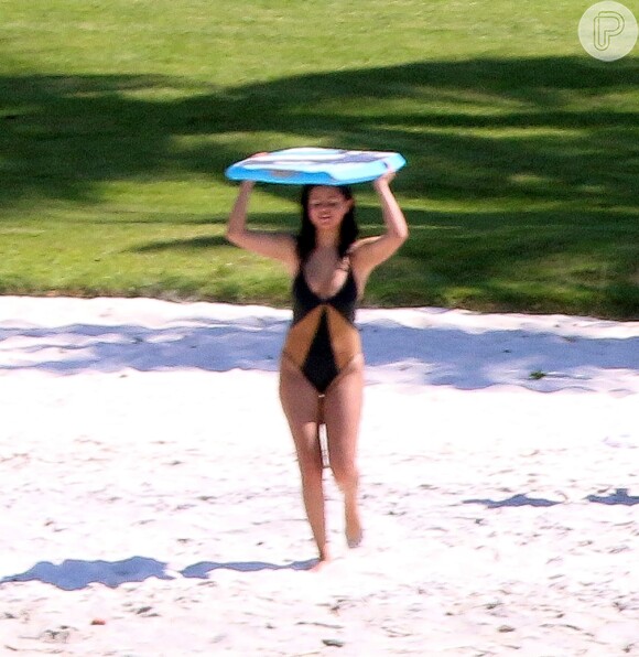 Selena Gomez curte sol no México e segue para o mar com seu bodyboard para surfar em praia. Segundo imprensa americana, cantora estaria grávida