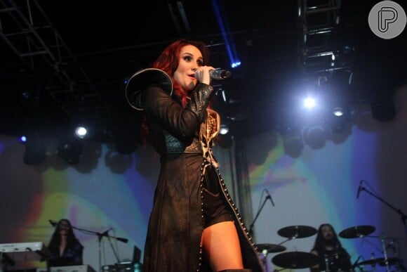 Dulce María usou um shortinho e capa preta no início de seu show em São Paulo