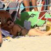 Fernanda Lima se bronzeia de bruços na praia
