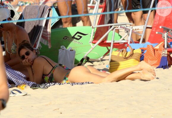 Fernanda Lima se bronzeia de bruços na praia