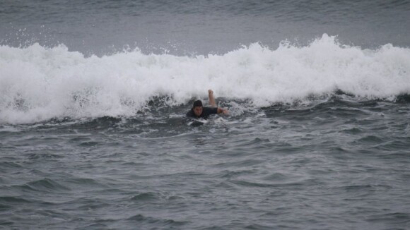 Vladimir Brichta surfa com o filho de Adriana Esteves em praia carioca