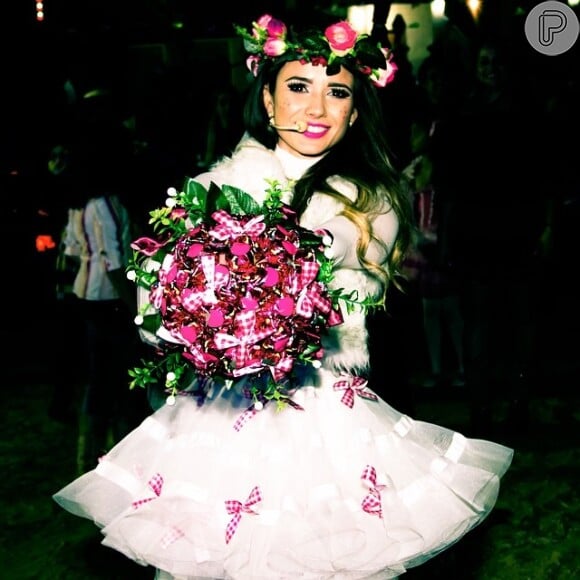 Paula Fernandes optou por um vestido de noiva curto e rodado, e completou o look com uma coroa de flores na cabeça