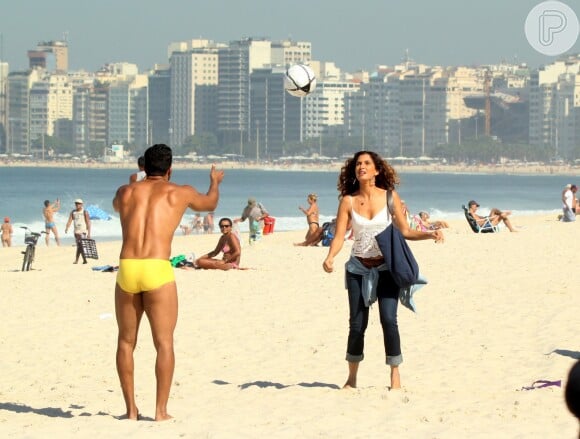 Camila Pitanga bate bola com homem sarado em praia carioca