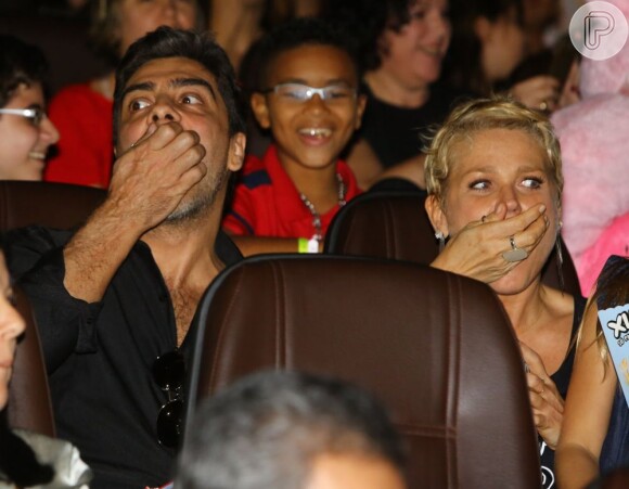 Xuxa e Junno comem pipoca enquanto assistem ao DVD  'Xuxa Só Para Baixinhos 12'