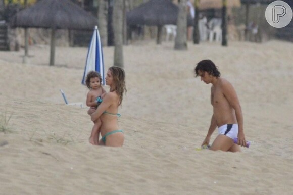 Letícia Spiller deixa a praia com a filha no colo