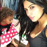 Kim Kardashian exibe seu decote e cachinhos da filha, North, com cara de sono