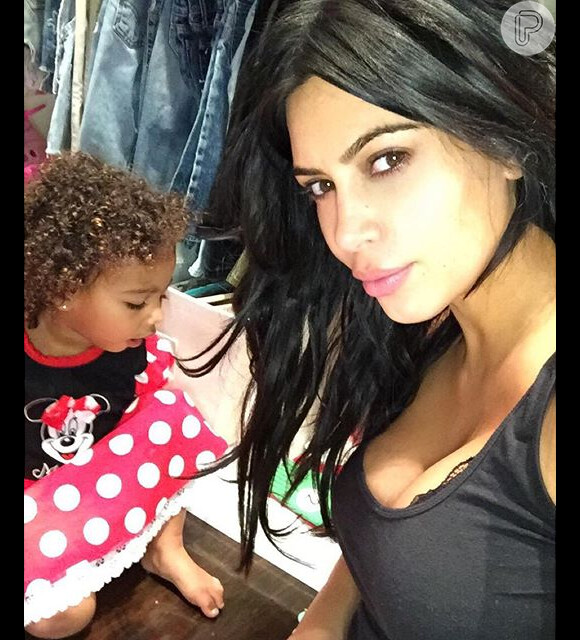 Kim Kardashian brindou seus seguidores com uma foto da filha, North, que aparece na foto com cara de sono e de cachinhos. Além da filha, socialite exibiu mais um de seus famosos decotes, nesta segunda, 28 de setembro de 2015