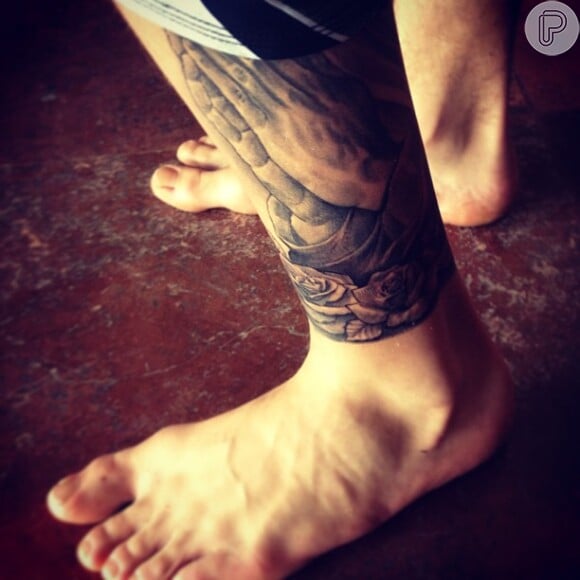 O cantor fez uma tatuagem de duas mãos em forma de oração na perna esquerda
