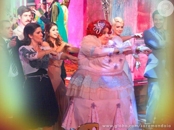 Dona Redonda (Vera Holtz) escolheu um vestido rosa cheio de babados para a festa de casamento de Zélia (Leandra Leal) e Lua (Fernando Belo) em 'Saramandaia'