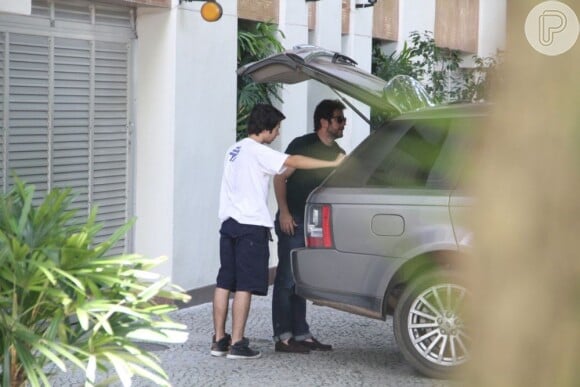 Murilo Benício coloca malas dele e de Débora Falabella dentro de seu carro, com a ajuda do filho, Antônio, em 18 de dezembro de 2012