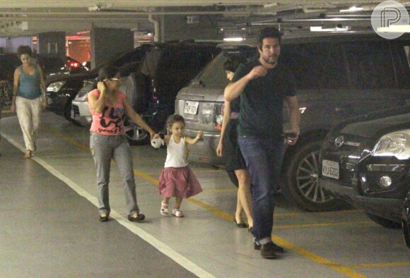 O ator anda na frente das meninas no estacionamento