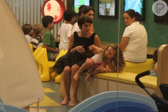 Nina, de 3 anos, se prepara para deixar o parquinho com Débora Falabella