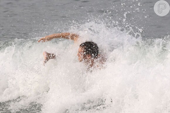 Sem se importar com a presença de banhistas na praia, o músico se jogou quando as ondas estouravam