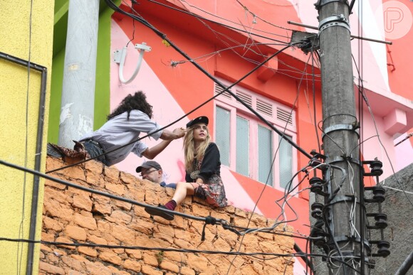 Cara Delevingne se arrisca em cima do muro aos cuidados do top maquiados Max Weber, durante ensaio fotográfico da grife Chanel, nesta quinta-feira (3), no morro Dona Marta, em Botafogo, Zona Sul do Rio de Janeiro