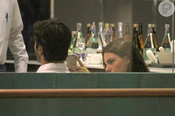 Isis Valverde não desgrudou do seu celular durante jantar com o namorado, André Resende