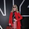 A socialite Val Marchiori optou por casaco vermelho Prada, vestido Fendi, bota Luis Vuitton e bolsa da Chanel para o look do quarto dia da SPFW, em 28 de abril de 2016