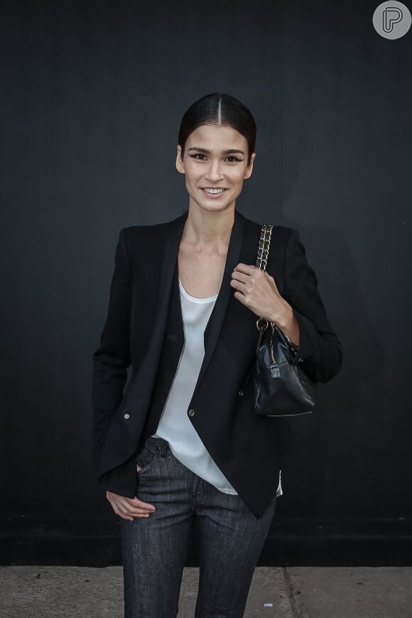 A modelo Carol Ribeiro combinou blazer com blusa de seda e calça jeans para o look do quarto dia de desfiles da SPFW, em 28 de abril de 2016