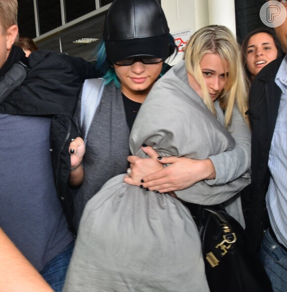 Demi Lovato desembarca no aeroporto de São Paulo com um travesseiro na mão