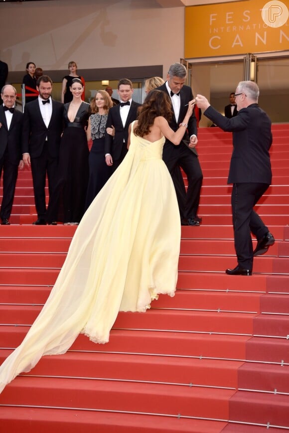 Amal Alamuddin, mulher de George Clooney, apostou em um longo com cauda imensa e passou por apertos ao subir a escada do Festival de Cannes