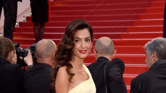 Amal Alamuddin, mulher de George Clooney, se atrapalha com vestido em Cannes