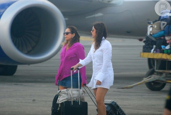 Daniela Mercury usava shortinho jeans e blusa rosa e Malu Verçosa investiu na bata branca para viagem