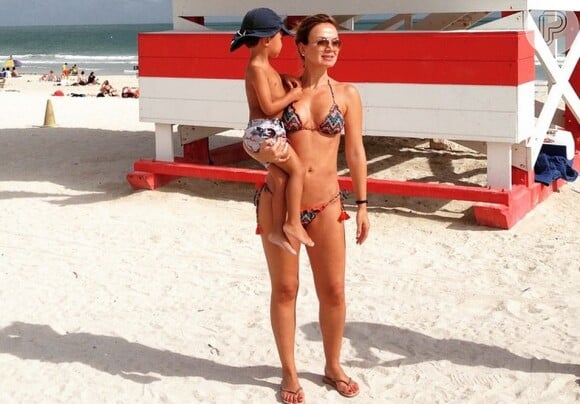 Eliana posa com o filho, Arthur, na praia e exibe boa forma