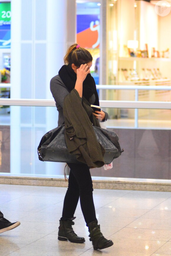 Sasha tentou esconder o rosto ao notar a presença do fotógrafo no aeroporto