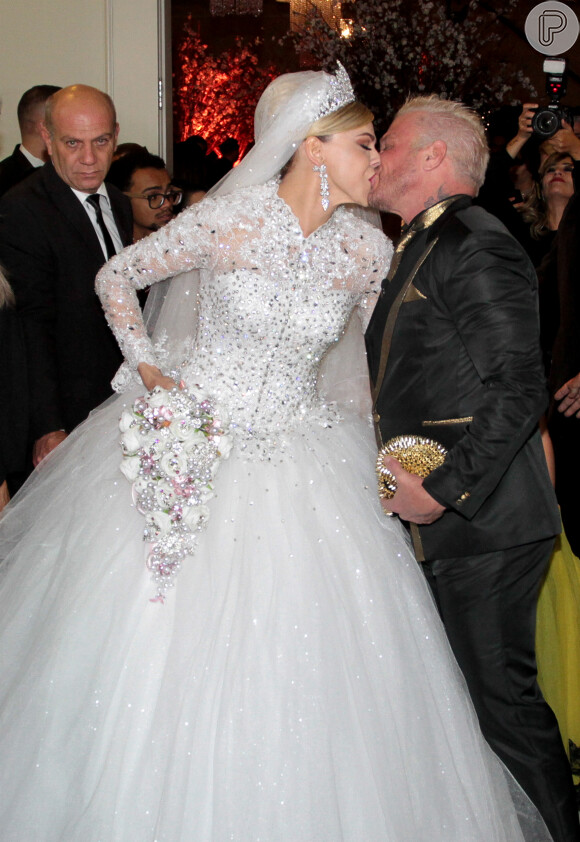 Com vestido luxuoso e com muitos brilhos, Léo Aquilla beija o marido, Chico Campadello, após cerimônia de casamento