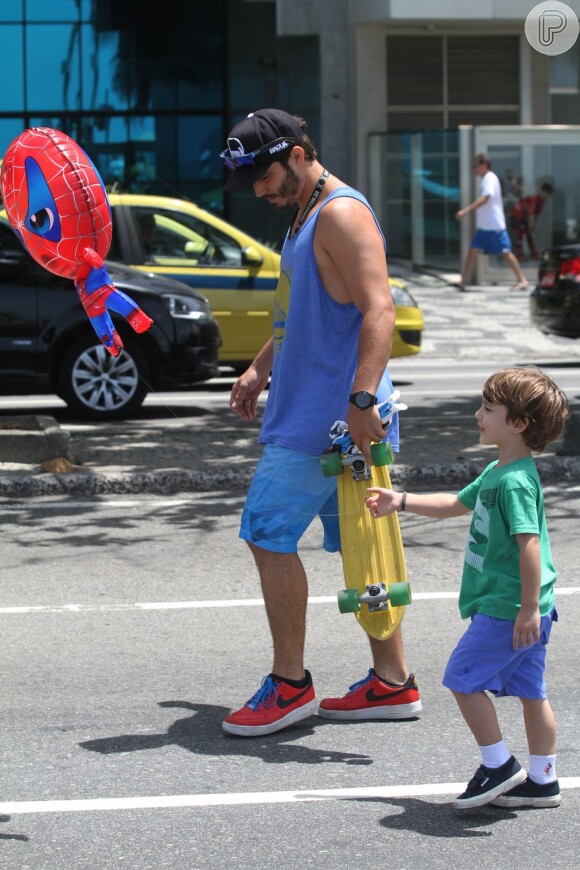 Thiago Rodrigues caminha com o filho, Gabriel, na orla do Leblon, na Zona Sul do Rio